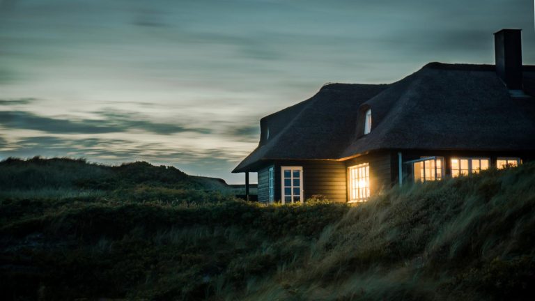 Home Bungalow aan zee boeken: uitzicht op strand met zee en een gezellige strandpaviljoens omgeving